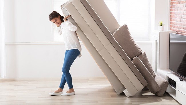 Woman Moving Sofa At Home | Mills Floor Covering