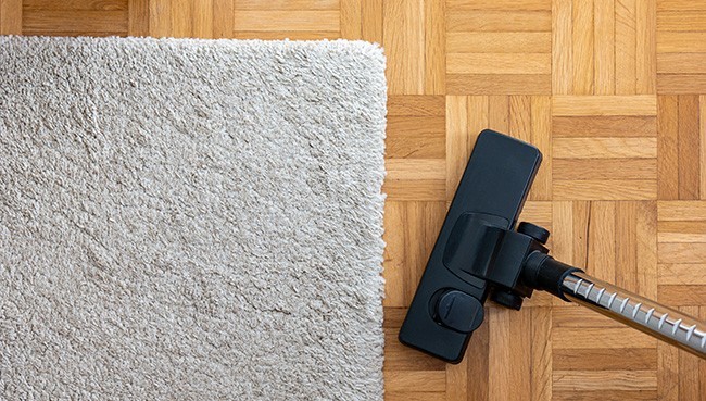 Vacuum cleaner extension on a laminated wooden floor | Mills Floor Covering