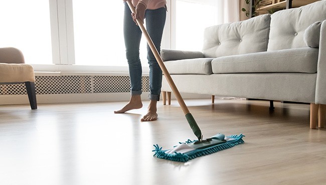 Barefoot woman cleaning floor | Mills Floor Covering